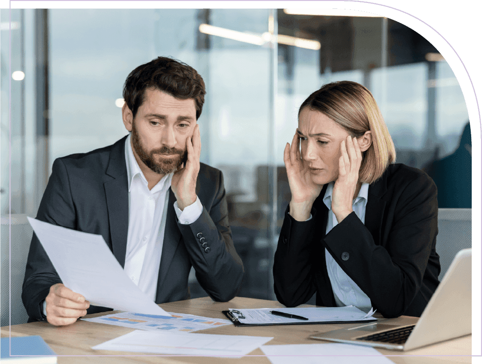 Two business professionals reviewing reports and discussing challenges in an office meeting