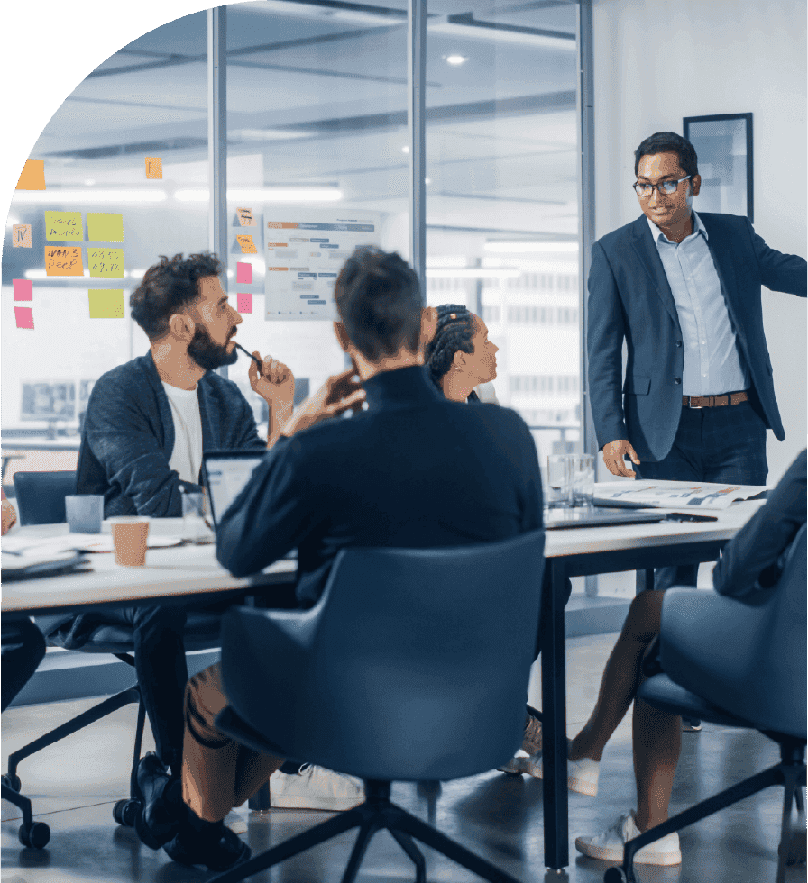 Team members collaborate in a meeting room while one colleague presents